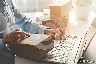 Person preparing online store orders for shipping using laptop Stock Photo