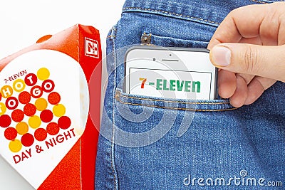 A person putting on a pocket an iPhone Plus with a 7-Eleven applications on the screen and Editorial Stock Photo