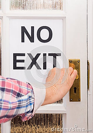 Person reaching for doorhandle with No Exit sign to coronavirus lock-down Stock Photo