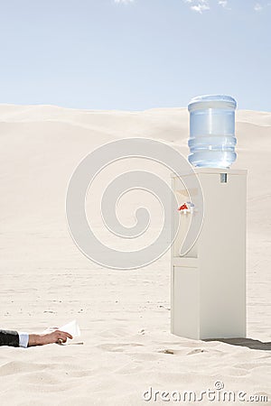 Person reaching for water cooler in desert Stock Photo