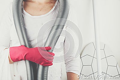Person with red rubber glove and a vacuum cleaner around neck Stock Photo
