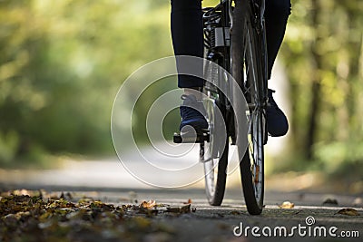 Person riding a bicycle along a fall road Stock Photo