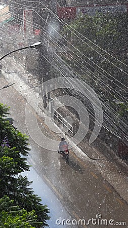 A person riding scooty in the rain in Nepal Stock Photo