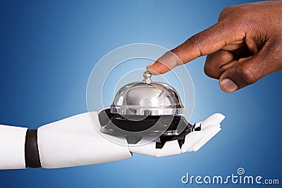 Person Ringing Service Bell Hold By Robot Stock Photo