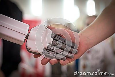 Person and robot shaking hands. Concept of human interaction with artificial intelligence Stock Photo