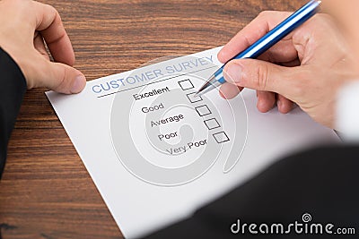 Person's hand filling customer survey Stock Photo