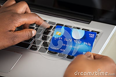 Person's Hand Using Debit Card While Shopping Online Stock Photo