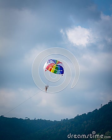 there is a person riding a kite on the beach with mountains in the background Editorial Stock Photo