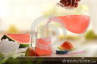 Person serving freshly prepared refreshing watermelon drink on kitchen bench Stock Photo