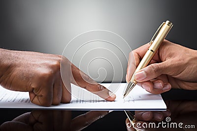 Person Signing On Document Stock Photo