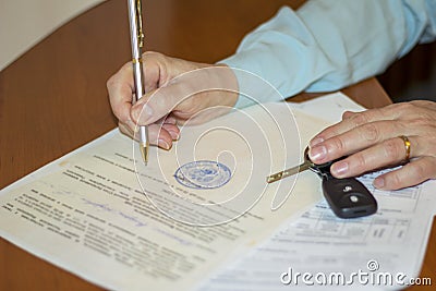 the person signing the document of purchase and sale of the car Stock Photo