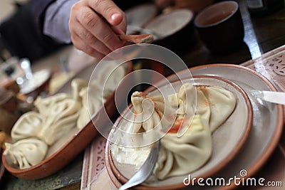 Person sprinkles with pepper Khinkali Stock Photo