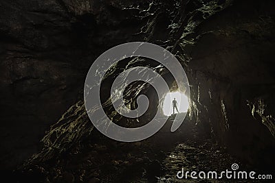 Person standing at the enlightened white exit of the dark tunnel - life starts blooming concept Stock Photo