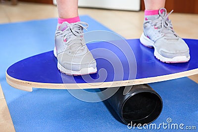Person standing on oval wooden deck for balance, close up view Stock Photo