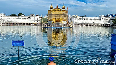 A person taking bath in the holy water at golden temple Amritsar Editorial Stock Photo