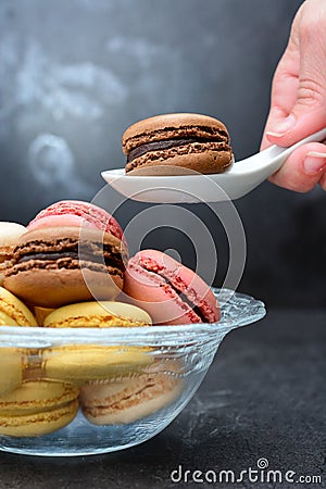 Person taking a macaron Stock Photo