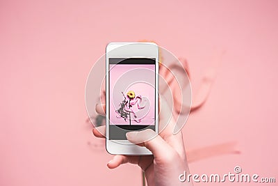 Person taking photo of flower with ribbon on smartphone. springtime concept Stock Photo