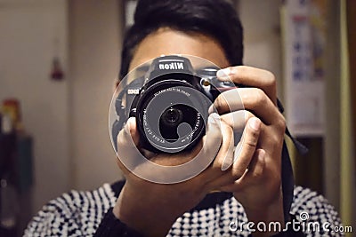 A person taking photo from his Nikon DSLR Camera facing camera Editorial Stock Photo