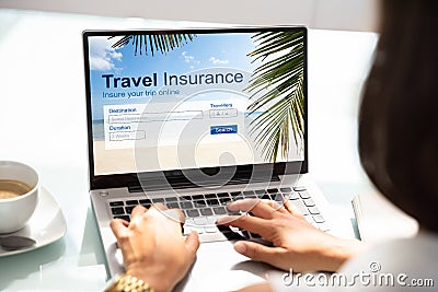 Person Using Laptop Working On Travel Insurance Application Stock Photo