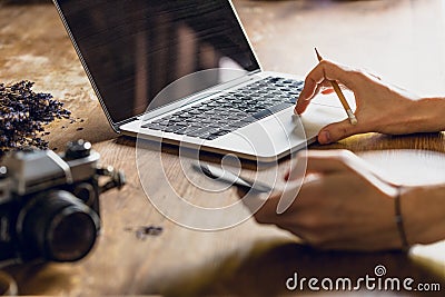 Person using laptop and smartphone at workspace with vintage camera Stock Photo