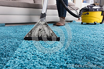 Person Using Vacuum Cleaner For Cleaning Carpet Stock Photo