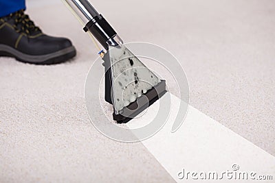 Person Using Vacuum Cleaner For Cleaning Carpet Stock Photo