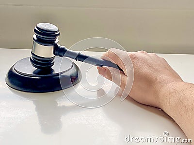 A person using Wooden Gavel with Round Block for Judge Lawyer Stock Photo