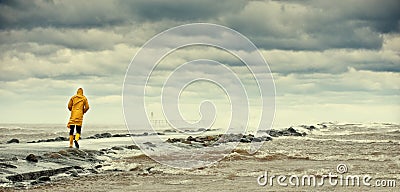 Person walking by stormy sea Stock Photo