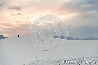 A person walking on a sand dune at White Sands National Monument in Alamogordo, New Mexico. Stock Photo