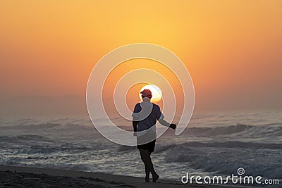 Person walks along Recreio dos Bandeirantes beach year sunrise Editorial Stock Photo
