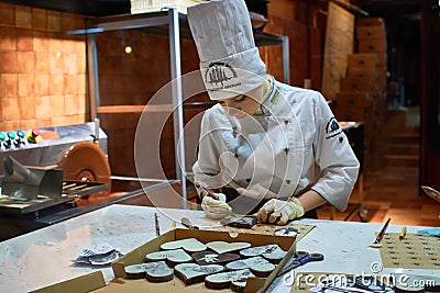 Person working inside of the Lviv Homemade Chocolate Factory. Editorial Stock Photo