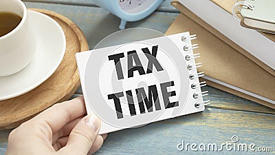 Person write word of Tax Time on notebook Stock Photo