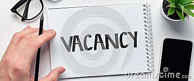 The person wrote the word vacancy in the notepad. Stock Photo