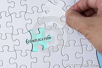 Person& x27;s Hand Holding Piece Of Puzzle With Word Complication. Stock Photo