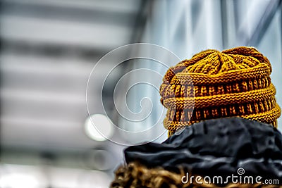 Person with a yellow knitted hat with blurred background Stock Photo