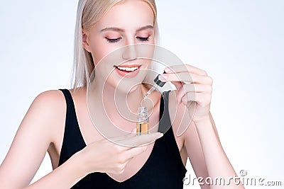Personable closeup woman applying CBD oil skincare treatment. Stock Photo