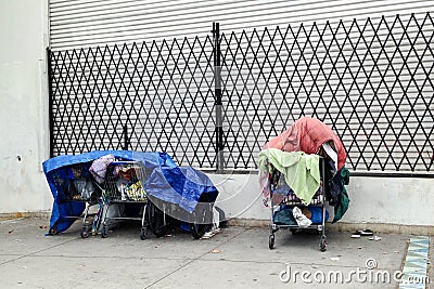 Personal belongings of homeless in shopping carts on sidewalk Stock Photo