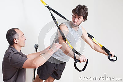 Personal coach explaining suspension training Stock Photo