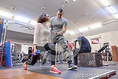 Personal fitness instructor helping summer woman exercising in health club. Health fitness sport age concept Stock Photo