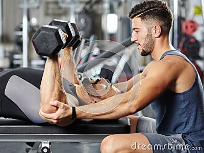 Personal instructor helping a man in the gym Stock Photo