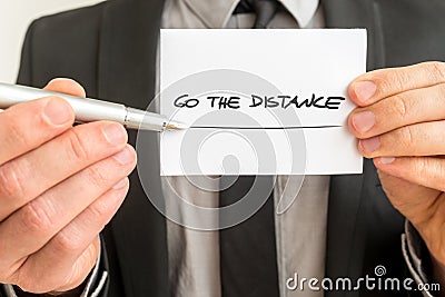 Personal motivator holding up a white card with a Go the distance sign Stock Photo