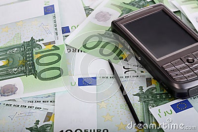 Personal pocket palmtop on money. Stock Photo