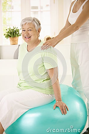 Personal trainer assisting senior woman Stock Photo