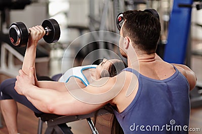 Personal trainer helping woman at gym Stock Photo