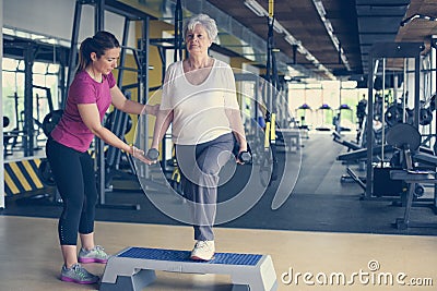 Personal trainer working exercise with senior woman in the gym. Stock Photo