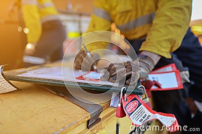 Personnel red danger locks attached with danger tags are locking on safety isolation permit lock box Stock Photo