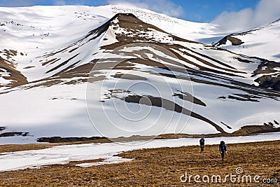 Persons Walking Tundra in Svalbard Stock Photo