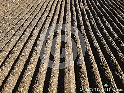 Perspective of deep grooves of sand. Background of raked white sand. Clean beach sand texture with rake. Maintenance of beaches Stock Photo