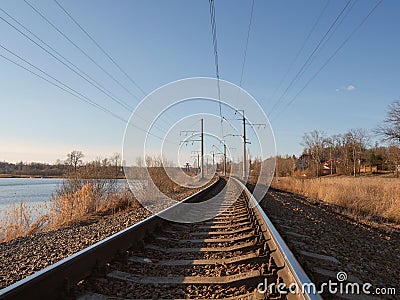 Perspective of rounded rails. Railway track turns and twists between out of focus hills background. Empty rounding and turning Stock Photo