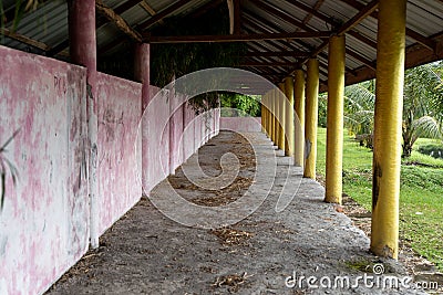 Perspective view of an empty small building with a wall and some yellow pillars Stock Photo